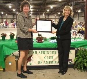 Welsh Springer Spaniel Club of America president Cindy Ford (left) accepts a certificate of appreciation from Sheila Goffe for her club's support of the AKC PAC.